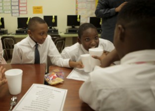 Some students at Forest Park Elementary in Boynton Beach are learning to be gracious young men during the Gentleman's Club, which meets after school every other Tuesday. Jevenson Antoine, left, tries to make a toast with his club mates. Randy Vazquez, Sun-Sentinel