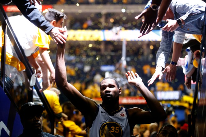 Golden State Warriors' Kevin Durant (35) gives fans high fives after his team defeated the San Antonio Spurs 99-91 in Game 5 of the NBA first-round playoff series at Oracle Arena in Oakland, Calif., on Tuesday, April 24, 2018. (Randy Vazquez/Bay Area News Group)