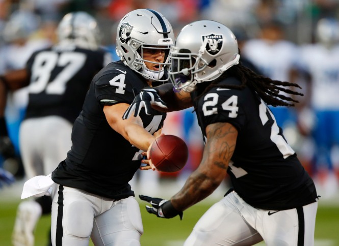 Oakland Raiders quarterback Derek Carr (4), left, hands the ball off to Marshawn Lynch (24), right, in the first quarter of their preseason NFL game at the Coliseum in Oakland, Calif., on Friday, Aug. 10, 2018. (Randy Vazquez/ Bay Area News Group)