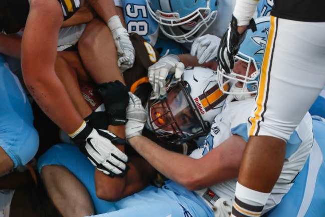 Saint Francis' Camilo Arquette (6), center, gets tackled by a group of Corona del Mar defenders during the first quarter of their game at Saint Francis High School in Mountain View, Calif., on Friday, Aug. 30, 2019. (Randy Vazquez/Bay Area News Group)